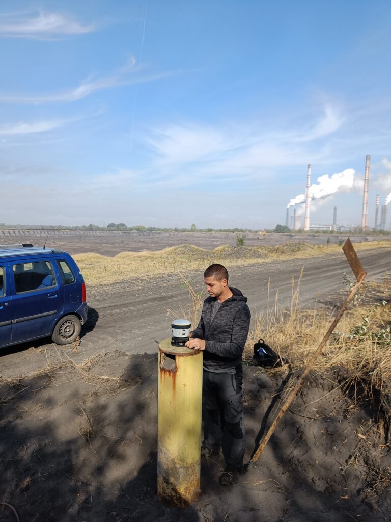 Surveyor with a total station monitoring deformations at the Maritsa East 2 power plant